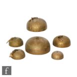 A graduated set of Tibetan/Burmese temple bells, each of plain domed form with ring loop