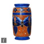 A 1930s Chameleon Ware Clews & Co footed barrel vase decorated with blue hand painted flowers and