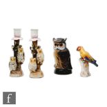 A pair of late 19th Century candlesticks each modelled with two owls perched on branches, height