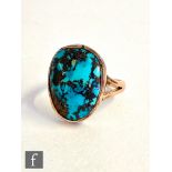 An early 20th Century 9ct rose gold single stone matrix turquoise ring, collar set stone to split