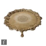 A George III hallmarked silver circular card waiter with engraved pattern over initials to centre,