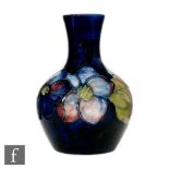 A small Moorcroft vase of globe and shaft form decorated in the Clematis pattern with a band of