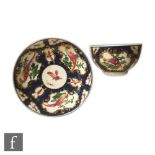 An 18th Century Worcester teabowl and saucer decorated with cartouche panels of fancy birds and