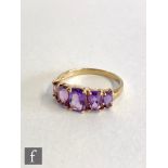 A 9ct hallmarked Edwardian style graduated five stone amethyst ring, claw set stones to plain