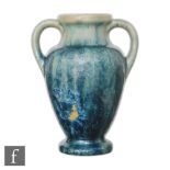 An early 20th Century Pierrefonds twin handled vase of footed baluster form, the whole decorated