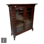 An Edwardian dark oak display cabinet fitted with shelves enclosed by a pair of glazed doors, height
