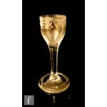 An 18th Century drinking glass circa 1750 with an ogee bowl engraved with a floral border above a