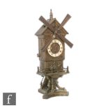 An early 20th Century brass novelty windmill clock in the form of a town house, striking on a gong
