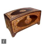 A Chinese Camphor wood chest, raised on four carved supports, with domed cover densely carved with