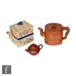 A collection of three Chinese Yixing teapots, the first of square section with toad finial and