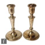 A pair of hallmarked silver candlesticks of plain form, circular bases below knopped columns and