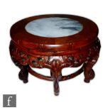 A Chinese hardwood jardinere or floor vase stand, the white marble round insert above six carved
