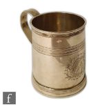 A George I hallmarked silver half pint tankard of plain form with engraved crest and reeded band
