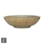 A Ruskin Pottery bowl decorated in an all over mottled blue and brown speckled glaze, impressed