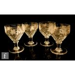 A set of four early 20th Century John Walsh Walsh wine glasses with fruiting vine design above a