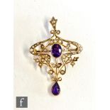 An early 20th Century 9ct amethyst and seed pearl open work pendant with central oval amethyst and