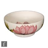 A Moorcroft Pottery footed bowl decorated in the Magnolia pattern with pink tubelined against a