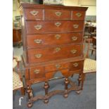 A George III oak chest on stand, the cornice pediment above an arrangement of nine drawers, all over