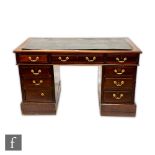 An Edwardian mahogany kneehole writing desk, the leather inset top over three frieze drawers and