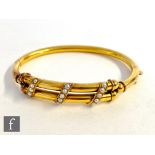 An Edwardian 18ct tubular hinged bangle detailed with three diagonal rows of seed pearls to front,
