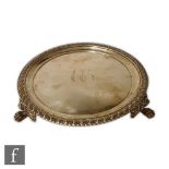A George III hallmarked silver circular small salver, plain body with engraved two initials within