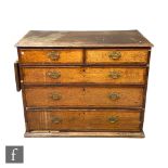 A George III mahogany crossbanded chest of two short and three long drawers, brass fret drop handles