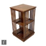 A reproduction hardwood revolving three-tier bookcase of square form, with lath supports over a