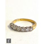 An 18ct hallmarked diamond seven stone diamond ring, claw set brilliant cut stones, total weight