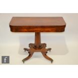 A Regency rosewood crossbanded D shape fold over card table on turned tapering pedestal and sabre