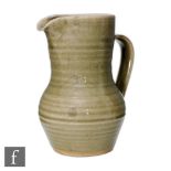 St Ives Pottery - A studio pottery flower jug decorated in an all over celadon green glaze,