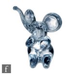 Daum - A contemporary clear crystal figure of a seated elephant with trunk raised, signed to the