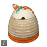 Clarice Cliff - Marguerite - A Beehive honey pot and cover circa 1933, with a floral relief