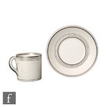 Grays Pottery - A moonstone glazed coffee cup and saucer with silver lustre banding, printed marks.