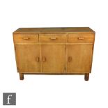 Cotswold School - An oak dresser, fitted with an arrangement of three frieze drawers with angular