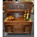 Unknown - An oak dresser with copper strapwork detail, the upright section with glazed double