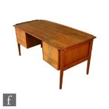 Dyrlund, Denmark - A teak desk fitted with an arrangement of six drawers to either side of the