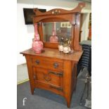 In the manner of Liberty & Co - An oak sideboard with fret-cut mirror panelled upright section, over