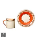 Susie Cooper - A coffee can and saucer with orange and black banding, printed mark.