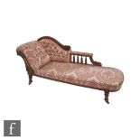 A Victorian walnut framed chaise longue upholstered in red pale leaf buttoned damask, on turned