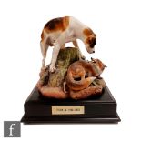 A later 20th Century coloured bisque model of a fox and hound, affixed to black plinth so any
