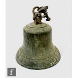 An early 20th Century cast metal bell by J Warner & Sons London with mounting, height 35cm. NB -