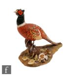 A Royal Crown Derby model of a pheasant perched on a branch, printed mark alongside XLIX and