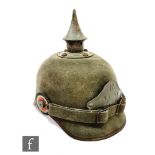 A World War One German Ersatz pickelhaube helmet in green cloth for R 22 division, original lining