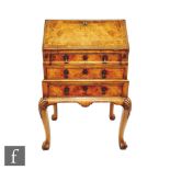 A small George I style crossbanded walnut bureau, the interior fitted with drawers and divisions