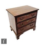 A small George III style mahogany chest of three long drawers, brass swing drop handles, on