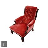 A Victorian mahogany framed easy chair, scroll arms on turned legs to the front, upholstered in pink
