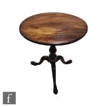 A George III circular mahogany occasional table with bird cage action, on baluster turned pedestal