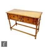 A small 1920s light oak geometric moulded front two drawer sideboard on spiral legs united by rail