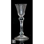 An 18th Century wine glass circa 1750, the pointed round funnel bowl above the stem with shoulder