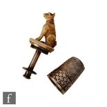A continental silver thimble with a carved ivory study of a seated dog, opening to reel holder and